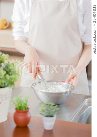 Women in an apron, whisk, bowls 23404832
