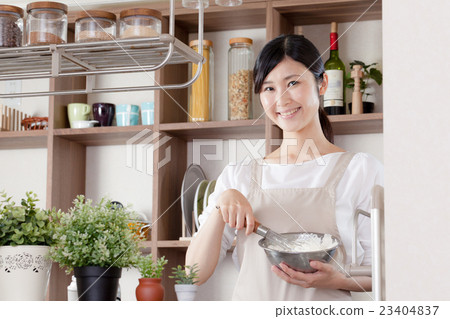 Women in an apron, whisk, bowls Women in an apron, whisk, bowls 23404837