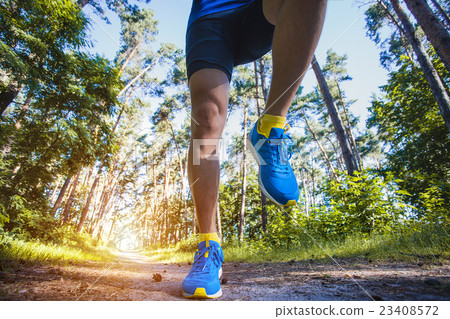 athlete running through the woods. athlete running through the woods. 23408572