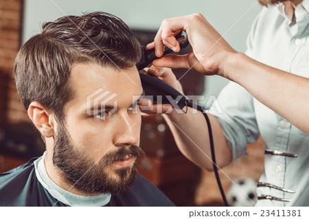 The hands of young barber making haircut 23411381