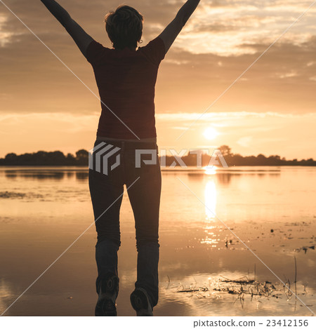 happy young slim woman jumping up on the shore of 23412156