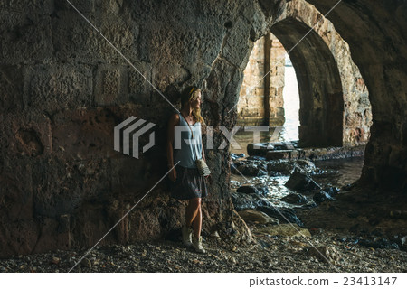 Young blond tourist woman stading in ancient stone Young blond tourist woman stading in ancient stone 23413147