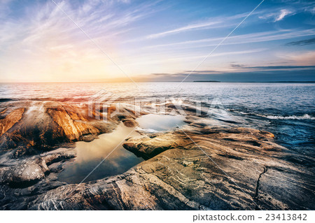 Stone coast of Ladoga lake at sunset 23413842