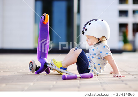 Toddler boy learning to ride scooter Toddler boy learning to ride scooter 23414866