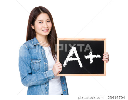 Woman with chalkboard showing A plus mark 23416704