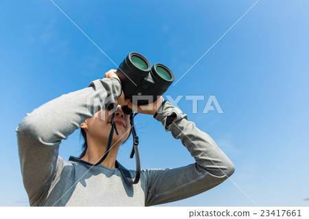Woman use of the binoculars for looking up 23417661