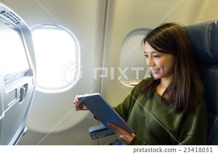 Woman use of digital tablet pc inside aircraft Woman use of digital tablet pc inside aircraft 23418031