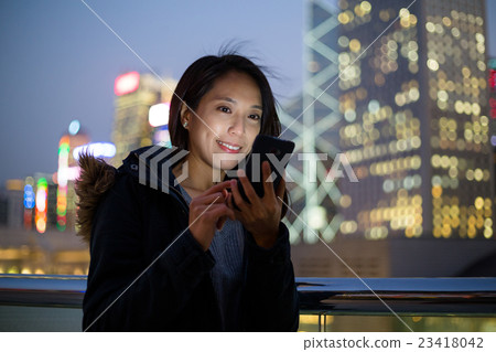 Woman using her mobile phone in Hong Kong 23418042