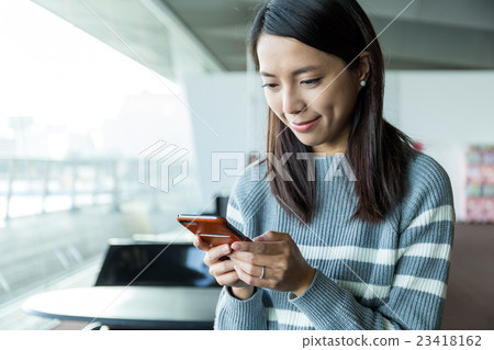 Woman use of cellphone in inddor cafe 23418162