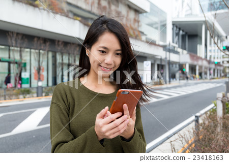 Woman use of mobile phone at outdoor 23418163