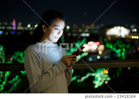 Woman use of mobile phone at night 23418164