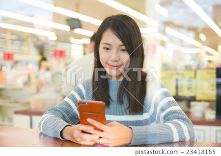 Woman using cellphone at coffee shop 23418165