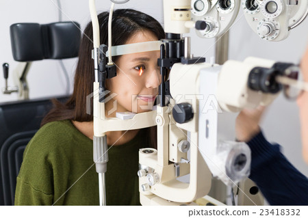 Woman having her eyes examined by eye doctor Woman having her eyes examined by eye doctor 23418332