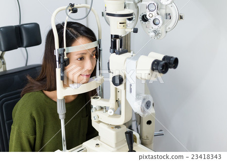 Woman doing eye test Woman doing eye test 23418343
