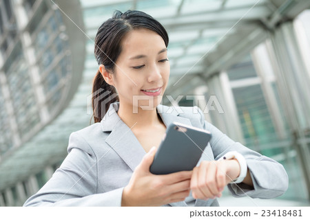 Business woman connecting smart watch and mobile phone 23418481