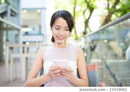 Woman use of mobile phone at outdoor cafe Woman use of mobile phone at outdoor cafe 23419062