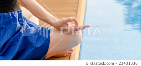Young woman meditating on a wooden deck Young woman meditating on a wooden deck 23431336