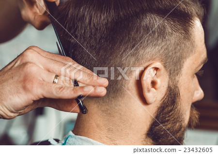The hands of young barber making haircut to 23432605