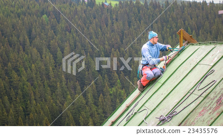 Man Working on the Roof, Checking Safety Gear Man Working on the Roof, Checking Safety Gear 23435576