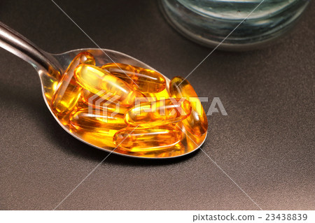 Fish oil in spoon with black background 23438839