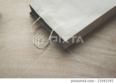 Paper bag on a wooden background 23442345
