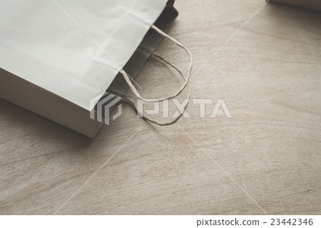 Paper bag on a wooden background 23442346