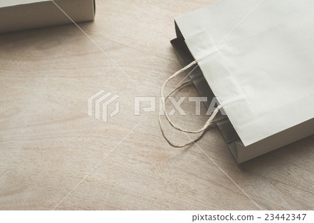 Paper bag on a wooden background 23442347