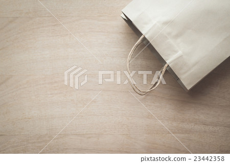 Paper bag on a wooden background Paper bag on a wooden background 23442358