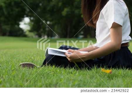 Student girl read and writing book in garden Student girl read and writing book in garden 23442922