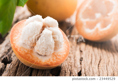 sliced santol fruit on wooden background 23449529
