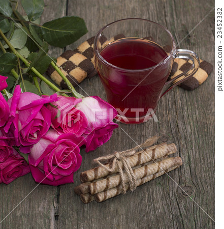 cup of tea, bouquet of roses and various cookies cup of tea, bouquet of roses and various cookies 23452382