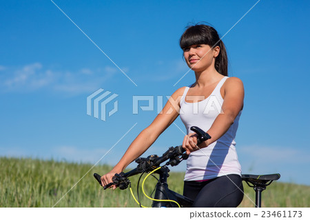 Sport bike woman on the meadow with a beautiful 23461173
