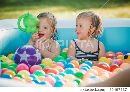 The two little baby girls playing with toys in 23467287
