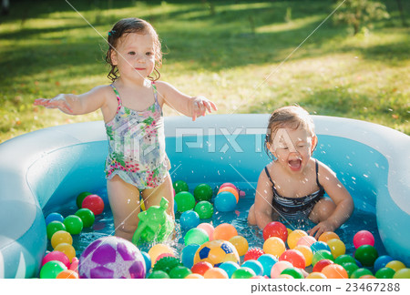The two little baby girls playing with toys in 23467288