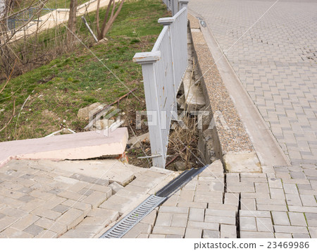 The destruction of the pedestrian walkway of stone tiles, and the brittle behavior of the fence The destruction of the pedestrian walkway of stone tiles, and the brittle behavior of the fence 23469986