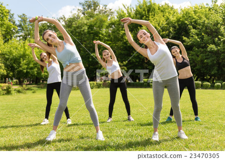 Positive women doing sport exercises outdoors Positive women doing sport exercises outdoors 23470305