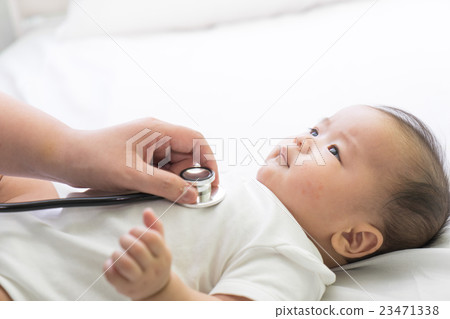 Doctor exams Asian newborn baby with stethoscope i 23471338