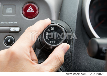man turning car air conditioner switch 23479023