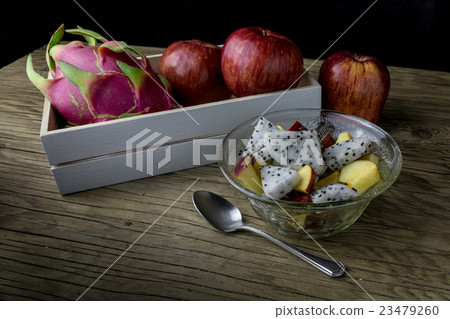 fruit salad in a bowl on the wooden table.  23479260