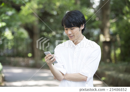 看智能手機的一個年輕人 看智能手機的一個年輕人 23486852