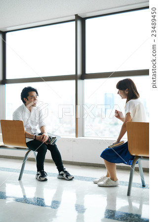 Male and female students relaxing in the lobby Male and female students relaxing in the lobby 23489450