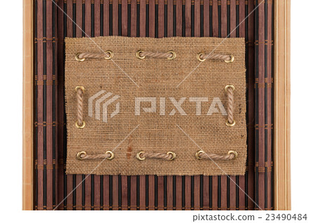 Frame made of burlap lying on a bamboo mat Frame made of burlap lying on a bamboo mat 23490484