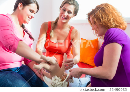 Midwife explaining birth process to pregnant women Midwife explaining birth process to pregnant women 23490983