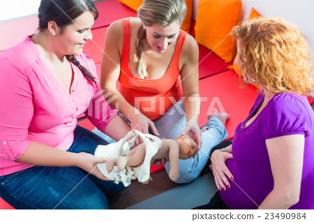 Midwife explaining birth process to pregnant women 23490984