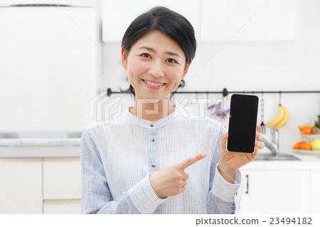 A woman pointing at a smartphone 23494182