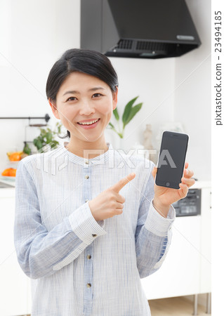 A woman pointing at a smartphone 23494185