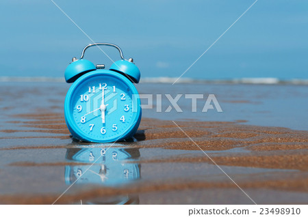 Retro alarm clock on sea beach sand. 23498910