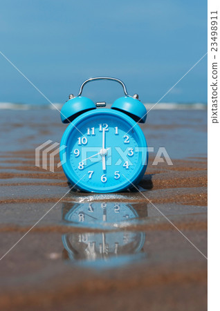 Retro alarm clock on sea beach sand. 23498911