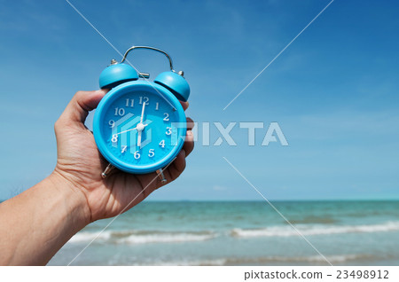 Hand is holding retro alarm clock. 23498912