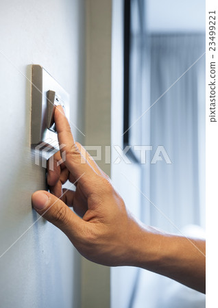 Finger is turning on a light switch. Finger is turning on a light switch. 23499221